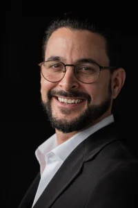 portrait-handsome-businessman-against-black-background-smiling_251136-89486